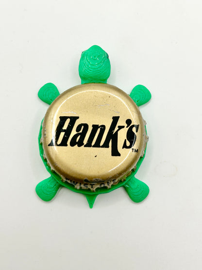 Hank’s Gourmet Beverages (Gold) - Bottle Cap Magnet Turtle Shell Shocked Art